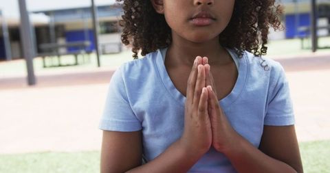 Young Girl Meditating Outdoors at School Reflecting Calmness