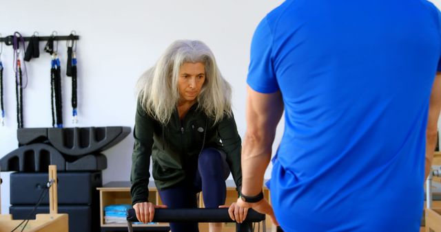 Senior Woman Doing Reformer Pilates Exercise with Instructor - Download Free Stock Images Pikwizard.com
