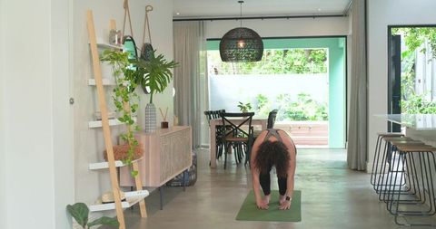 Home yoga morning stretching in bright minimalist open-plan living space