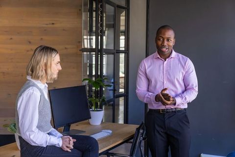 Diverse Coworkers Discussing in Modern Office Environment