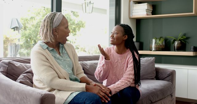 Happy african american senior mother and adult daughter sitting on couch and talking, slow motion - Download Free Stock Photos Pikwizard.com