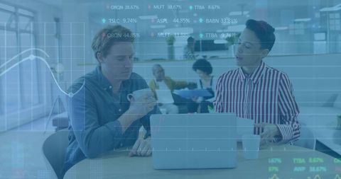 Team discussing financial data on laptop with stock market overlay in open-plan office