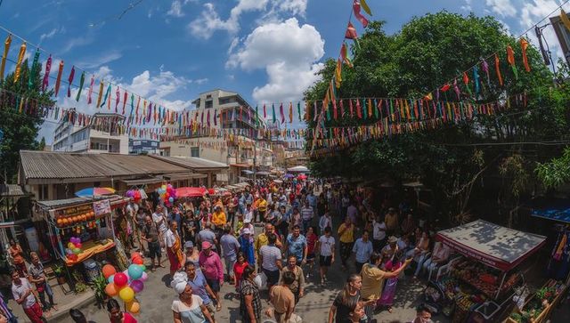 Vibrant street market festival flowing with colorful pennant flags and busy crowds