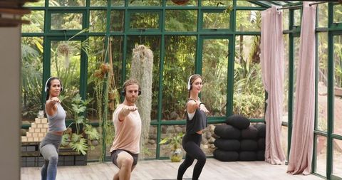 Group yoga in serene glass house studio