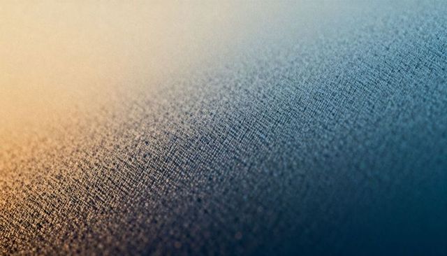 Macro textured fabric gradient with glittering bokeh and fine metallic grain