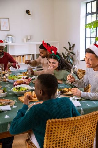 Multicultural Family Celebrating Christmas Dinner at Festive Table