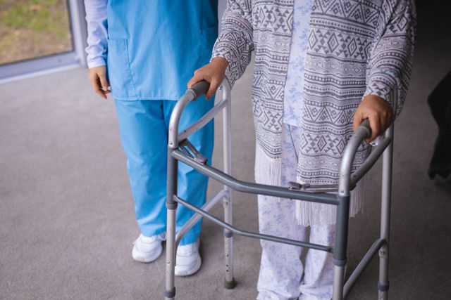Midsection of asian female nurse and senior patient using walker. senior healthcare and medical physiotherapy treatment.