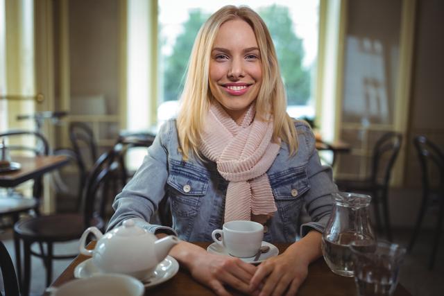 Portrait of smiling woman sitting with a cup of coffee in cafÃ©