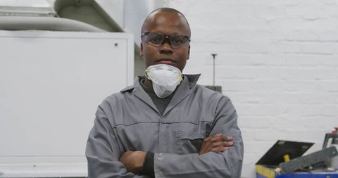 Confident African American Mechanic in Workshop with Protective Gear
