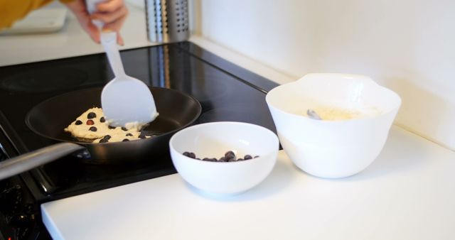 Person Making Blueberry Pancakes on Stove in Modern Kitchen - Download Free Stock Images Pikwizard.com