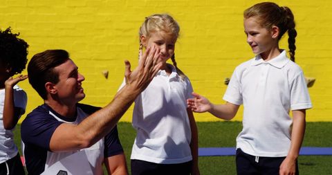 Teacher and Girl High-Fiving in Outdoor Sports Activity