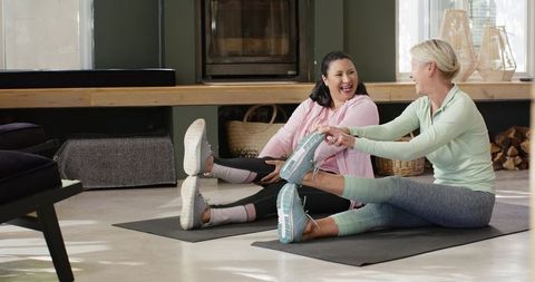 Senior women engaging in home stretching routine for wellness