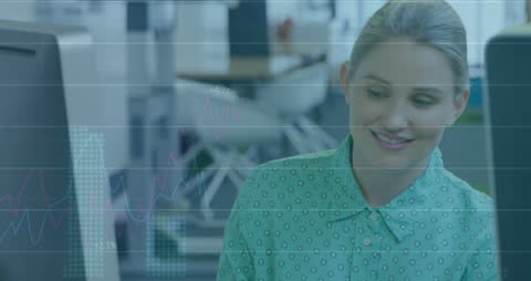 Businesswoman Analyzing Data on Computer in Office Environment