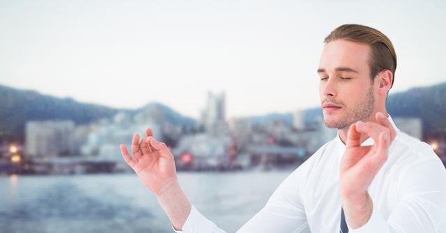 Digital composite of Business man meditating against water and blurry skyline