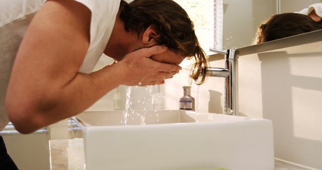 Man Washing Face in Modern Bathroom Sink in Morning Light - Download Free Stock Images Pikwizard.com