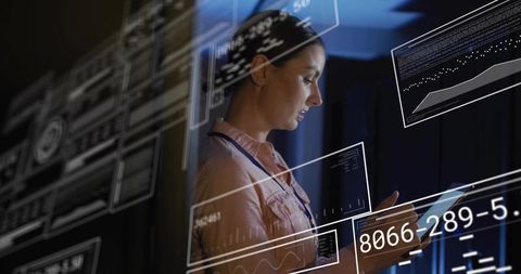 Female IT technician analyzing augmented dashboard on tablet in futuristic control room