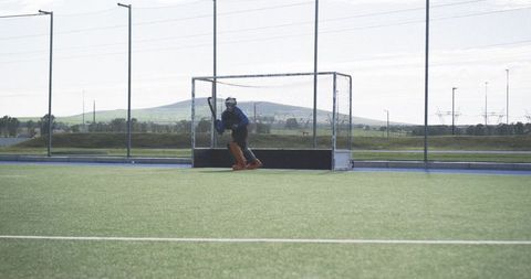 Male field hockey goalkeeper in gear on turf field