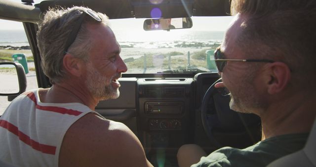 Happy caucasian gay male couple driving car and talking on sunny day at the beach - Download Free Stock Photos Pikwizard.com