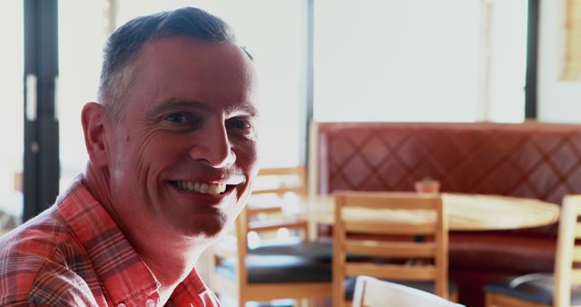 Smiling Man Sitting in Cozy Restaurant - Download Free Stock Images Pikwizard.com