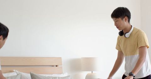 Young man packing foundation box in modern bedroom for relocation