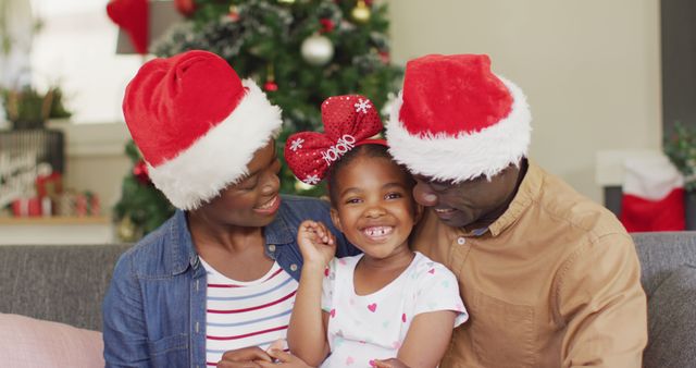 Portrait of happy african american family with santa hats. Spending quality time with family at christmas concept.
