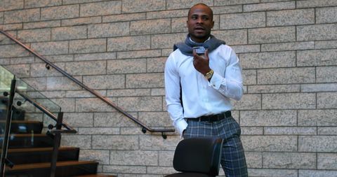 Businessman conversing on phone in office hallway