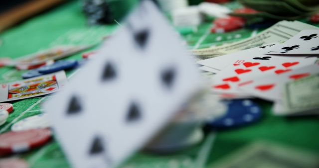 Close up of playing cards and casino chips over green surface. Casino, card games and gambling concept.