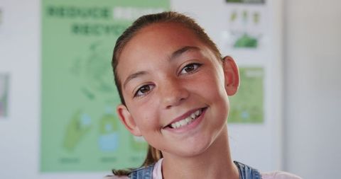 Cheerful schoolgirl engaged in recycling education at school