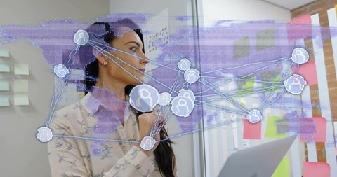 Female analyst studying and analyzing global network overlay on glass with sticky notes