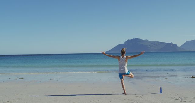 Woman Practicing Yoga on Serene Beach with Scenic Mountain View - Download Free Stock Images Pikwizard.com