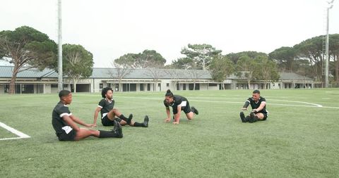 Soccer players warming up before practice on grass field