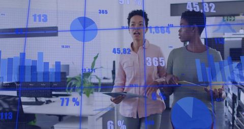 Business Women Discussing Holographic Data Visualizations in Office