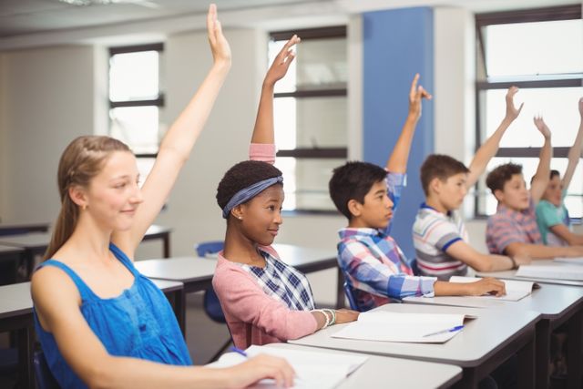 Students of diverse backgrounds actively participating in a classroom setting, raising their hands to answer or ask questions. Ideal for educational materials, school brochures, websites, and articles about student engagement, diversity in education, and classroom activities.