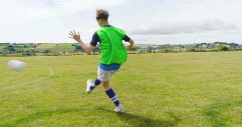 Athletic Soccer Player Kicking Ball on Sunny Field