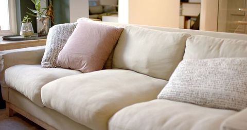 Scandinavian beige sofa with dusty rose pillow chic living space