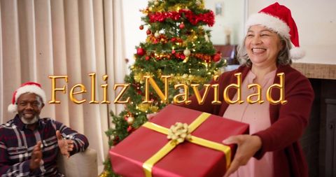 Senior Friends Exchanging Christmas Gifts with Feliz Navidad Message - Download Free Stock Images Pikwizard.com