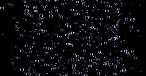 Twinkling confetti and air bubbles on black background