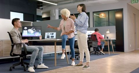 Diverse Team Discussing Project in Modern Office with Computers