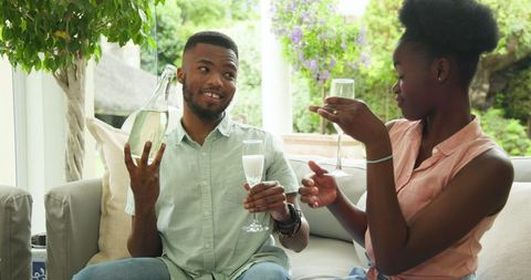 Couple Enjoying Drinks Together on Cozy Outdoor Sofa
