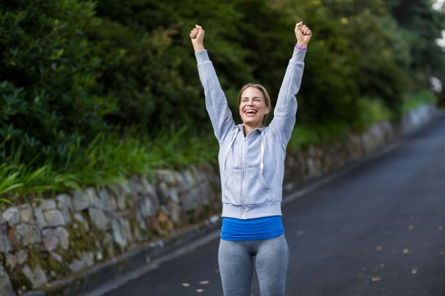 Excited Woman Celebrating Outdoors with Arms Raised - Download Free Stock Photos Pikwizard.com