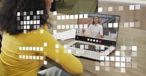 Watching virtual meeting on laptop woman in yellow top with digital pixel overlay