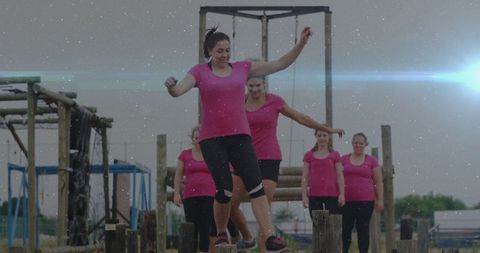 Women team navigating obstacle course in fields