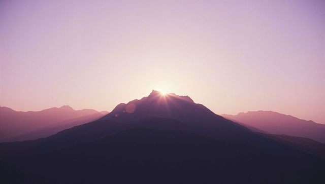 Mountain Peak at Sunrise with Lens Flare and Sun Rays