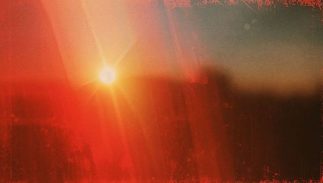 Fiery sun with dramatic lens flare and textured horizon