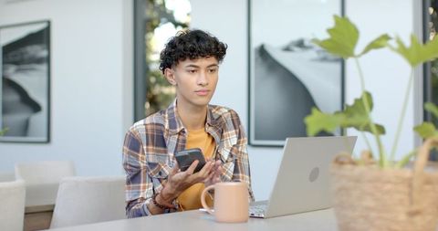 Young Man Working Remotely With Laptop and Smartphone