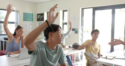 High School Students Raising Hands in Classroom for Participation