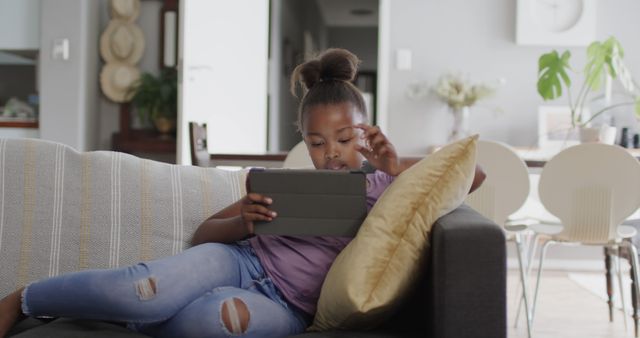 Young Girl Relaxing on Couch Using Digital Tablet at Home - Download Free Stock Images Pikwizard.com