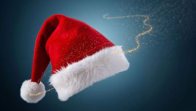 Floating Santa Hat Trailing Gold Glitter on Moody Blue Backdrop for Festive Design