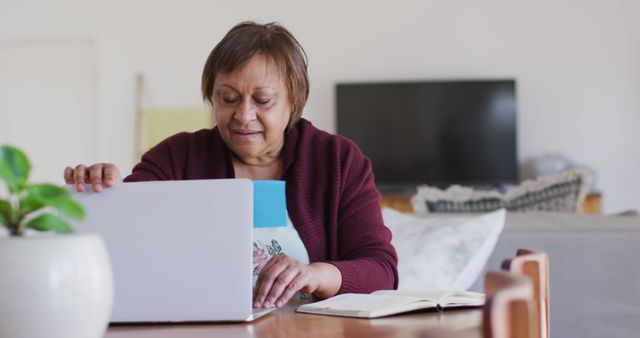 Elderly Woman Sitting at Table with Laptop and Notebook - Download Free Stock Images Pikwizard.com