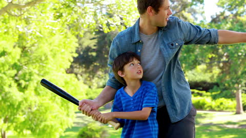 Father and Son Practicing Baseball in Park